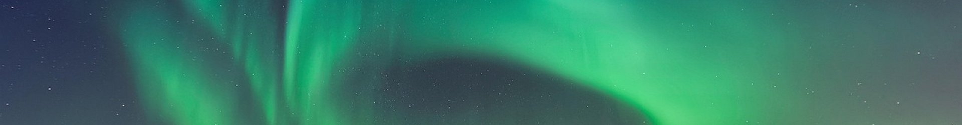 Bright green auroras glowing across a dark Alaska night sky during a Northern Lights display.