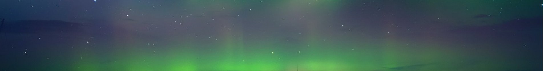 Dark Alaska night sky filled with bright green Northern Lights glowing across the horizon.