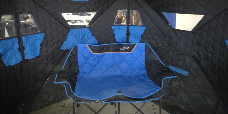 Loveseat chair inside an insulated tent in Alaska, designed for couples relaxing during winter adventures.