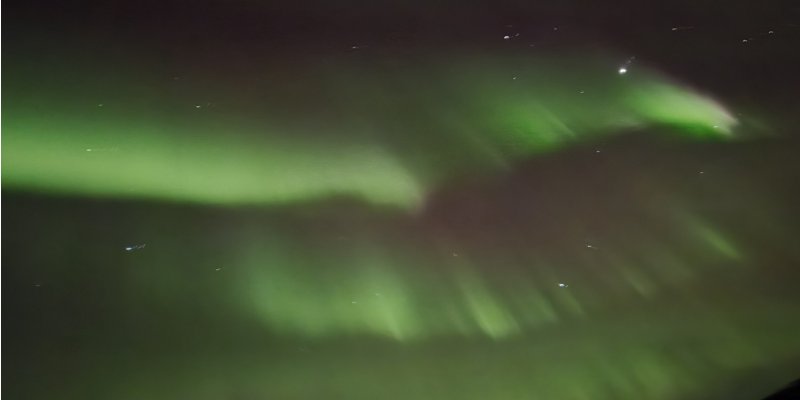 Northern Lights viewed from Ester Dome overlooking Fairbanks with vibrant auroras above the Alaska night sky