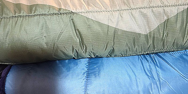 Rolled Auroralander Backcountry Blanket add-on in multiple colors layers, compact camping gear for wearable warmth during aurora viewing with Denali Backroads.