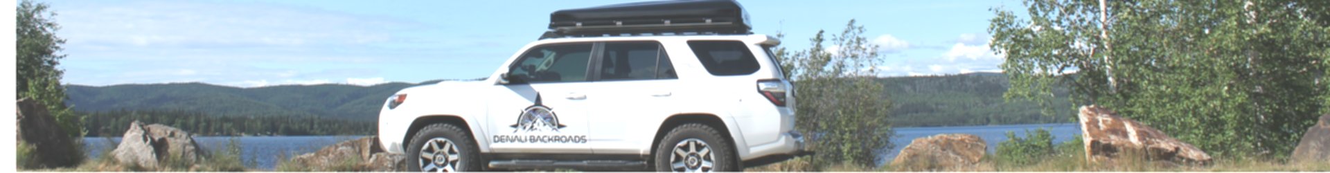 White Denali Backroads Overland 4Runner parked beside an Alaska lake with rooftop iKamper tent.